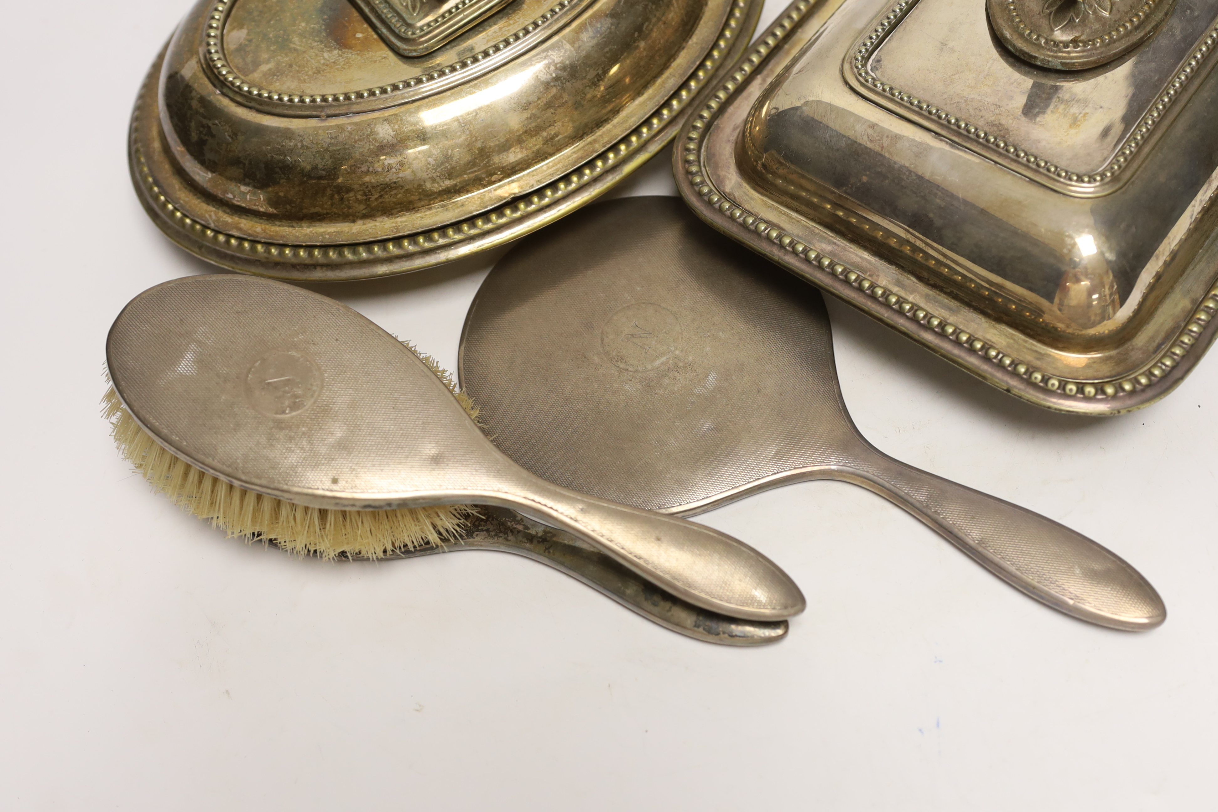 Three plated entrée dishes and a silver dressing table set